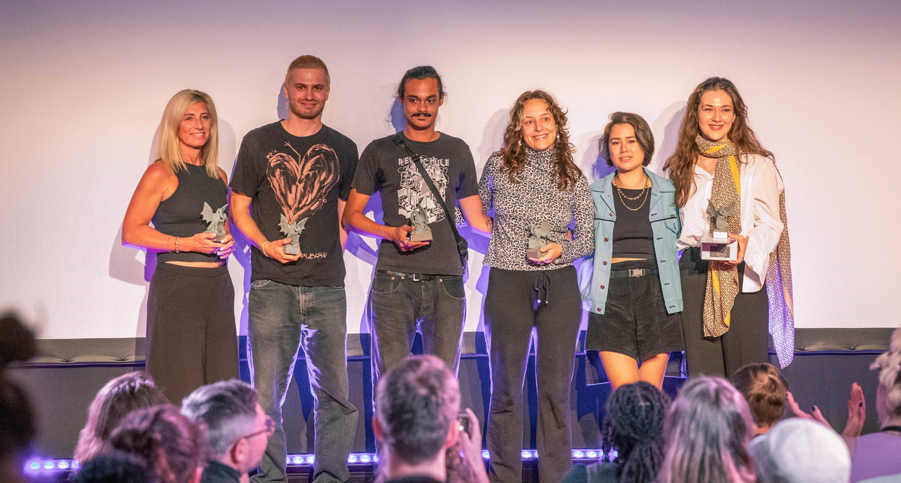 aulona_gewinnerin.jpg Menschen auf Bühne Festivalgewinn